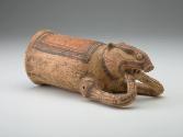 A ceramic drinking vessel positioned on its side, resembling a piglike animal decorated with red and black designs.