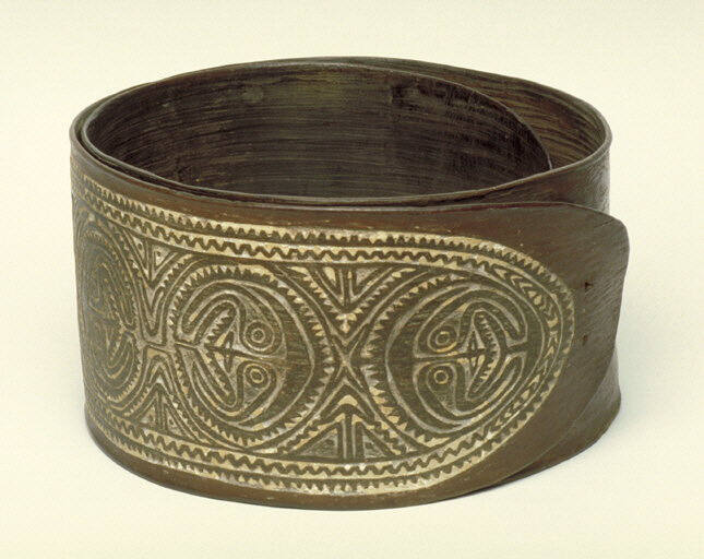 Bark belt with relief carvings of human faces